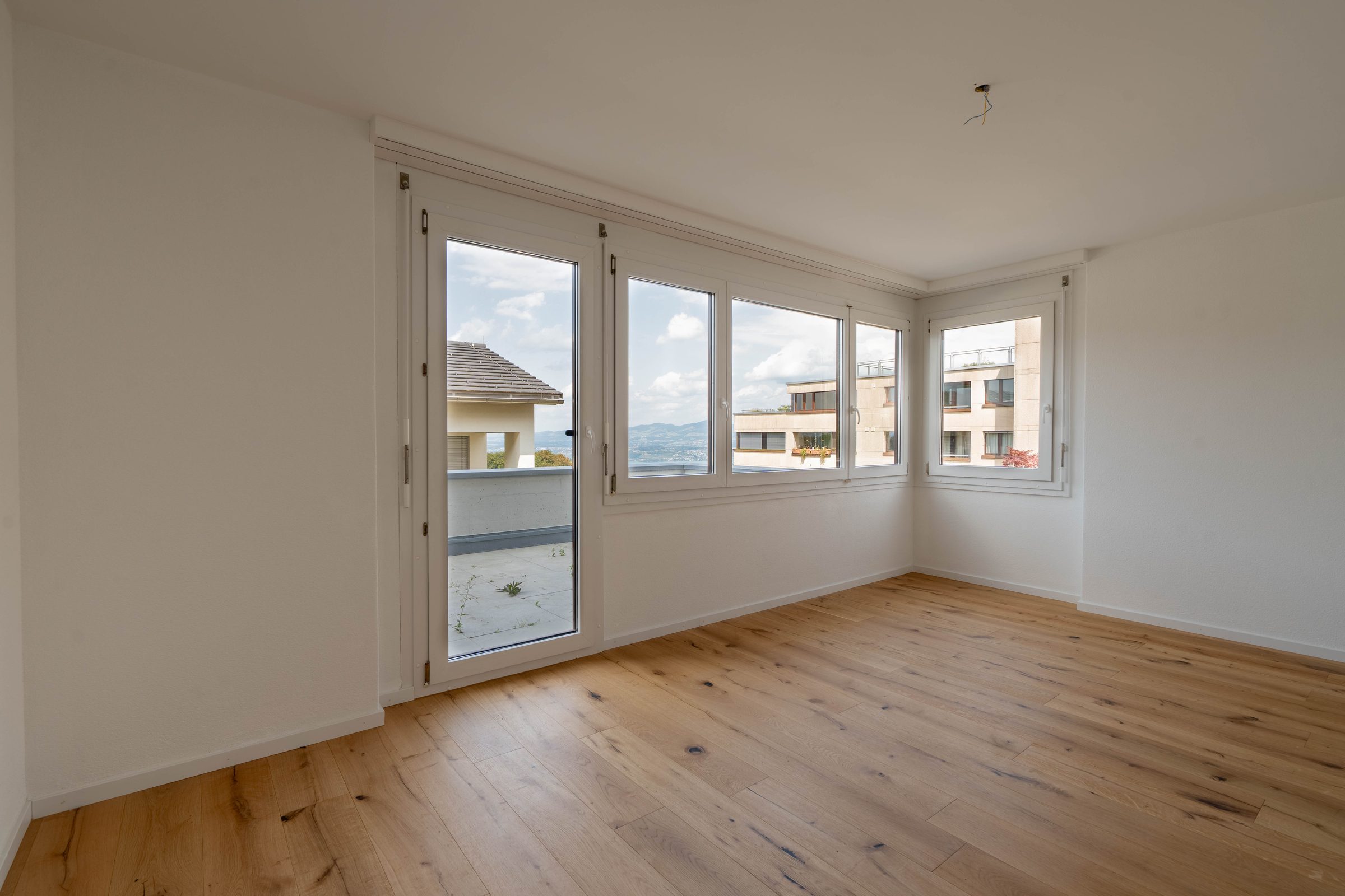 Zimmer mit Balkonzugang und Panoramafenstern