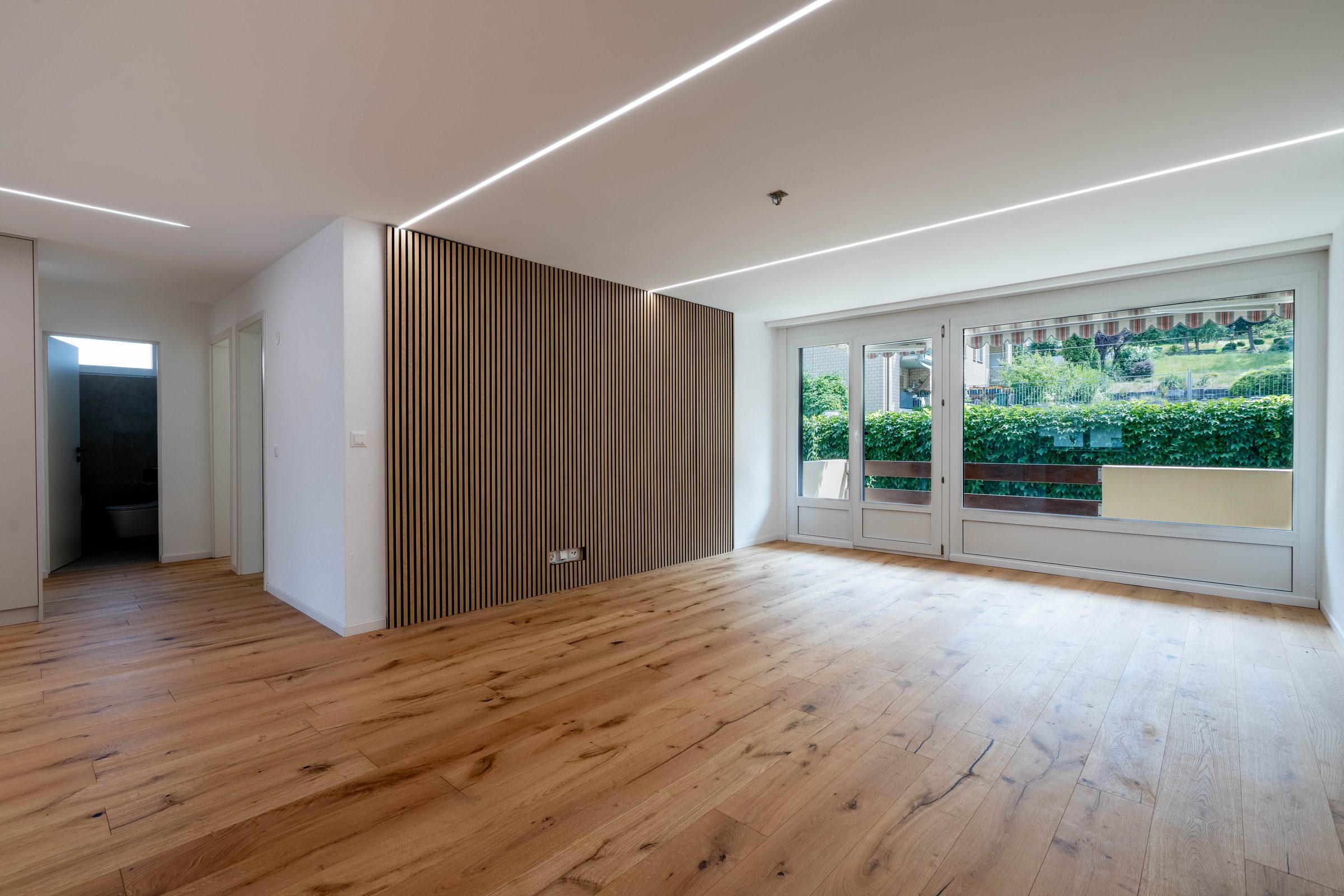 Wohnzimmer, zweite Perspektive mit Holzlamellenwand